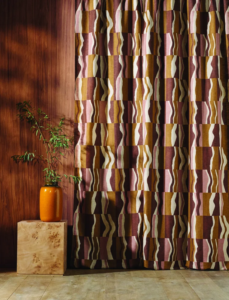 Curtains 11 Isara curtain fabric in plum, pink and ochre geometric block print against a walnut wall - Melksham Blinds